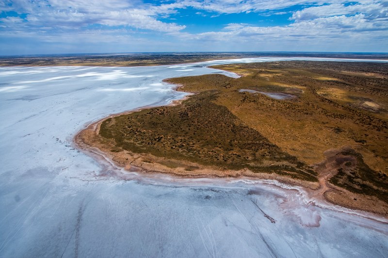 a drone shot of a coastline along empty plains, desolate coastline 4k