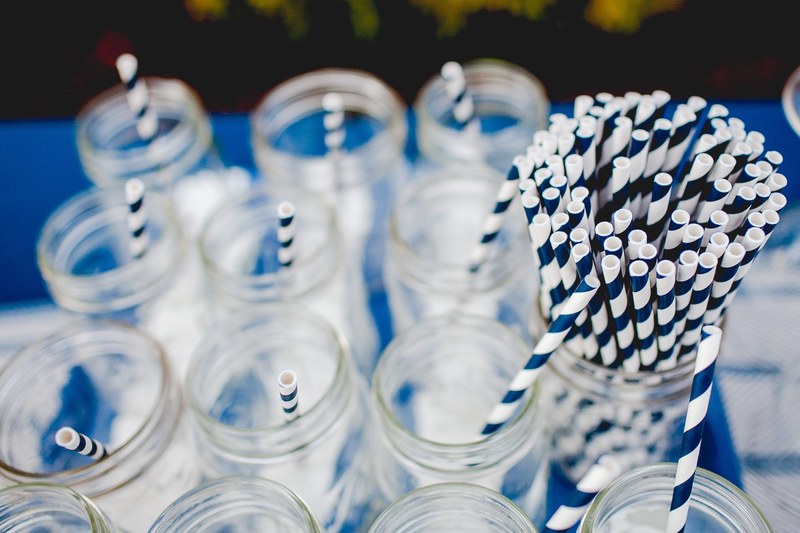 a selection of mason jars with blue and white striped straws ahead of a party, blue and white party straws in mason jars 4k