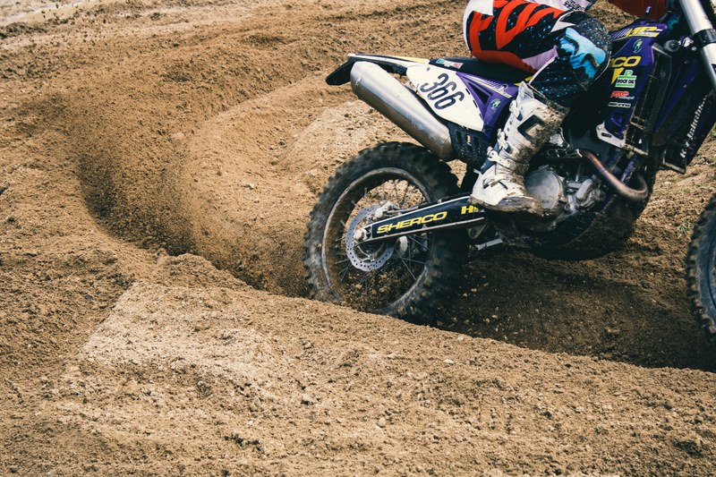 person in boots on a dirt bike on dirt track speeding on track, dirt bike on dirt track 4k