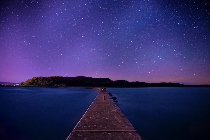 the land as seen from the extended pier across the sea under a starry night, _land extended pier night 4k