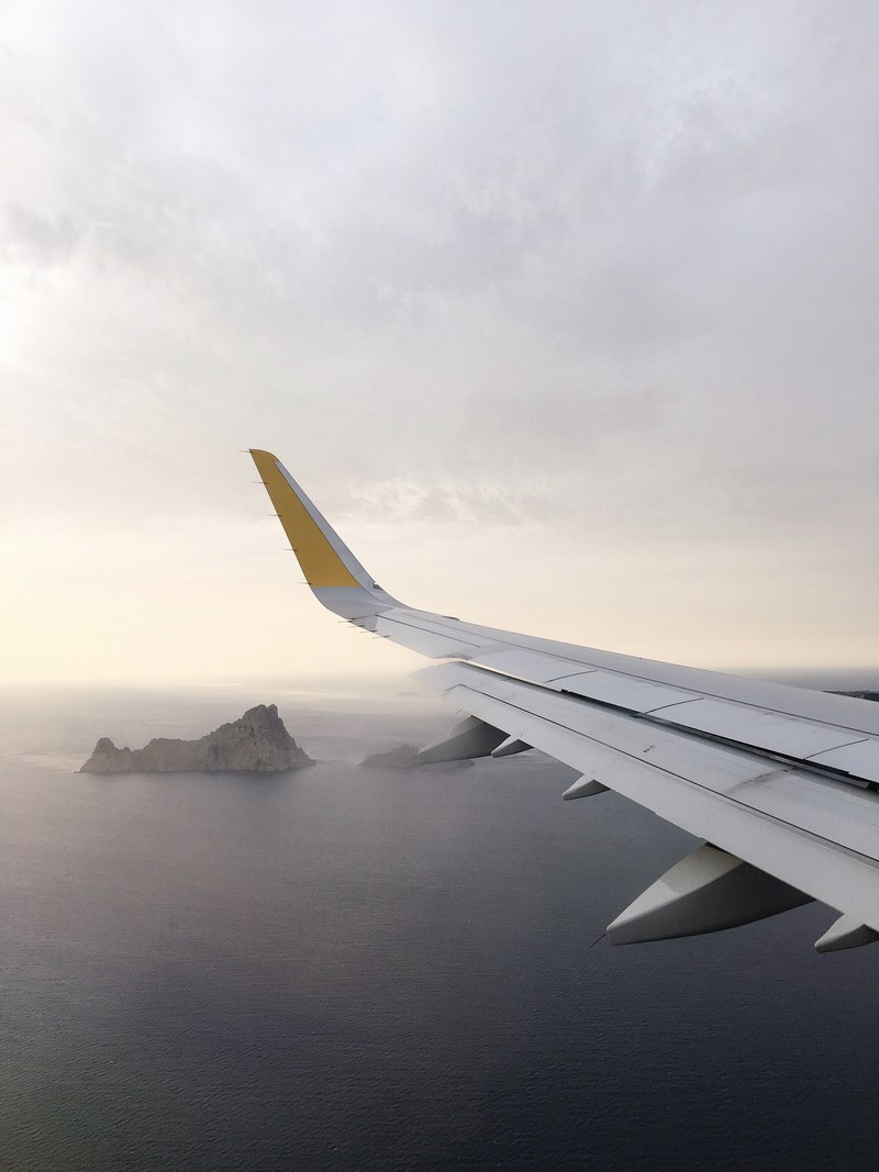 a view from an airplane window on the surface of the ocean with rocky islands jutting out of the water, ibiza i see you 4k