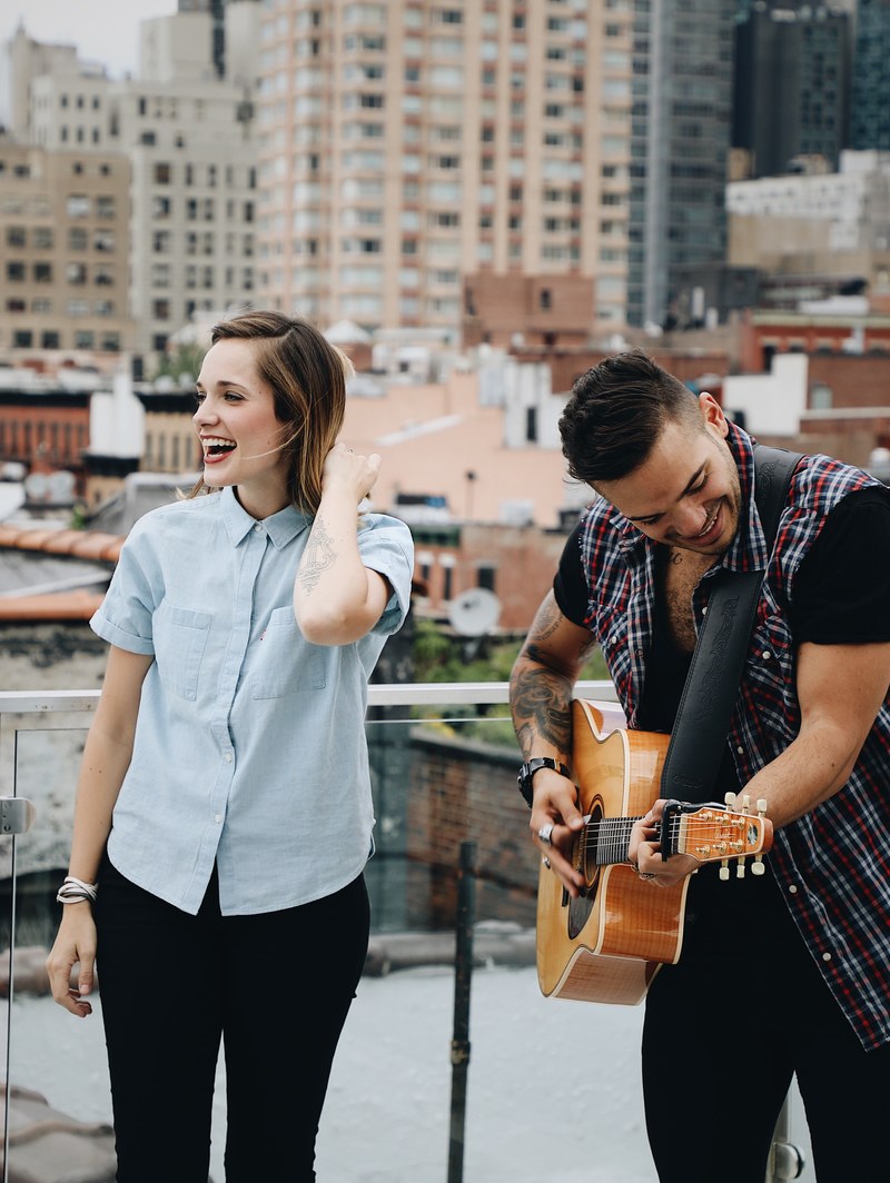 a man playing guitar next to a happy girl, _guy playing guitar 4k