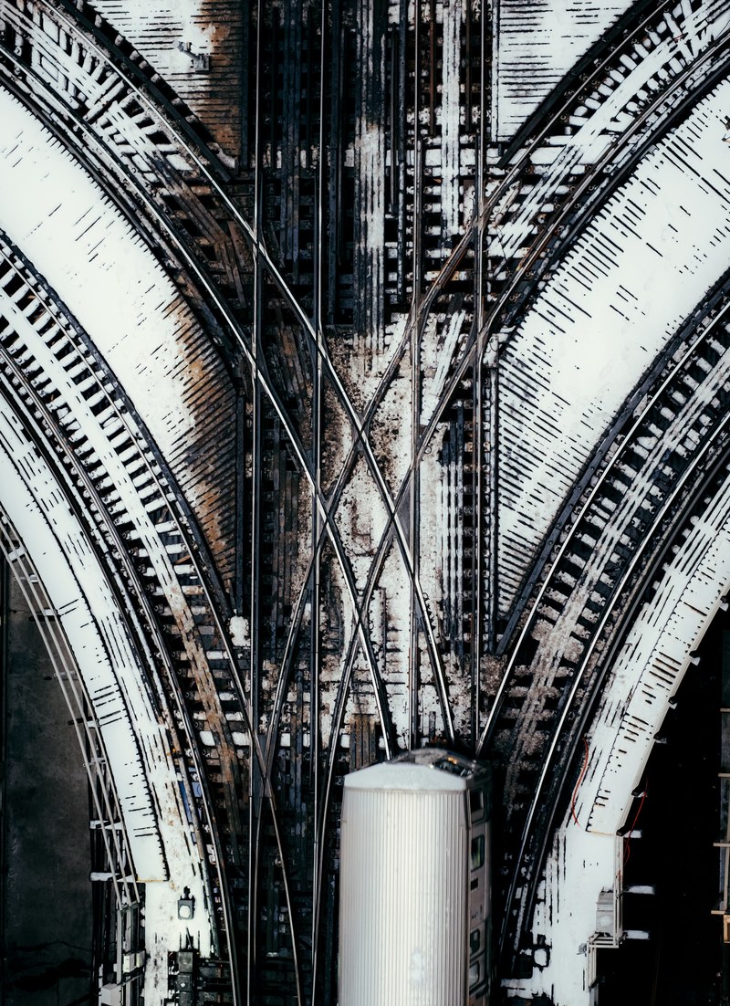 an aerial shot of a train running through a railroad junction, top view of a chicago railway junction 4k