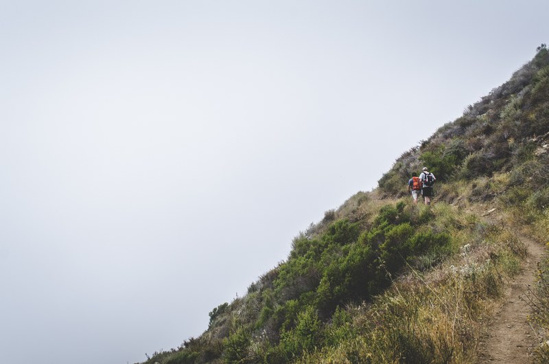 two backpackers on a footpath on a steep slope, hikers on a steep slope 4k