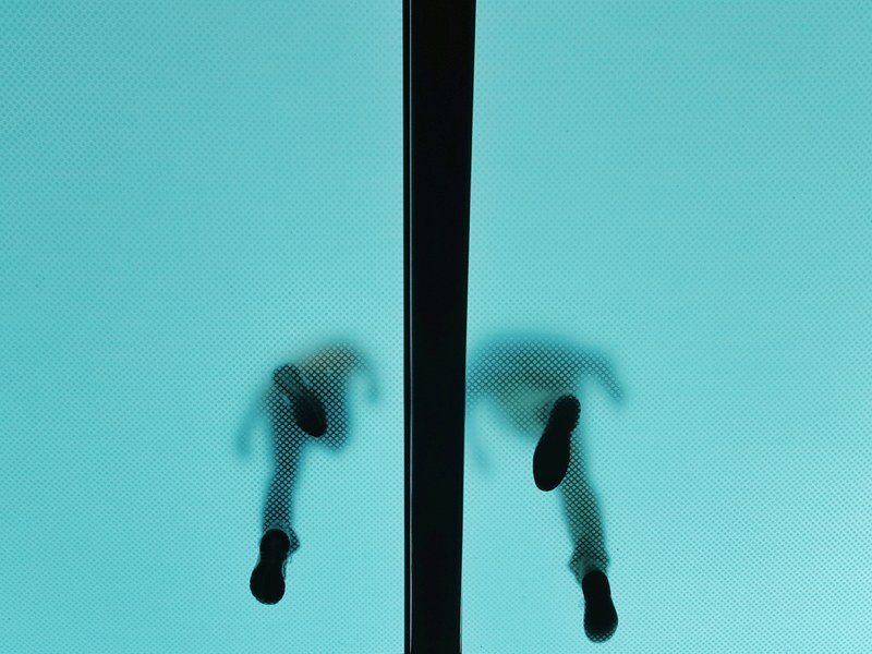 the shoeprints of two people walking on a level above seen through a translucent ceiling, feet on a translucent ceiling 4k