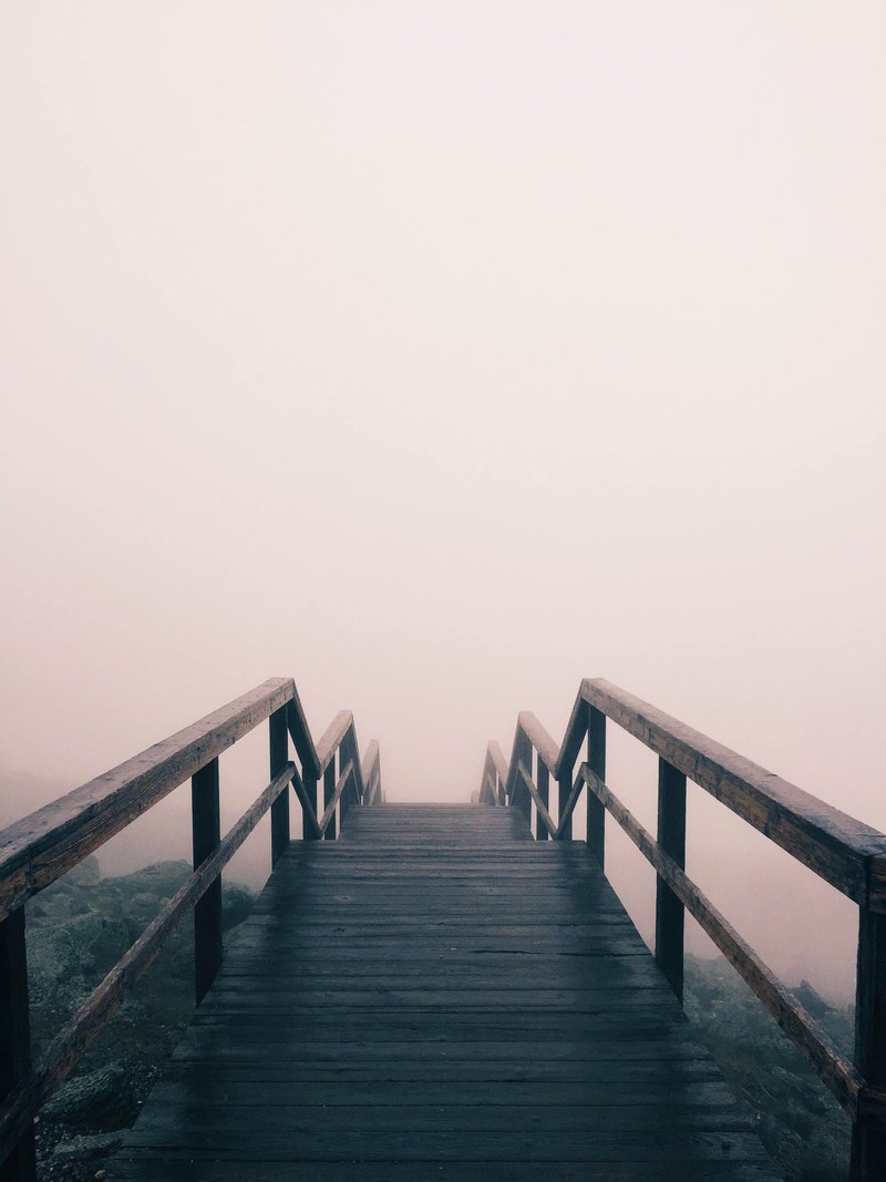 stairs lead down a rocky hillside and disappear into fog, descent into the mist 4k