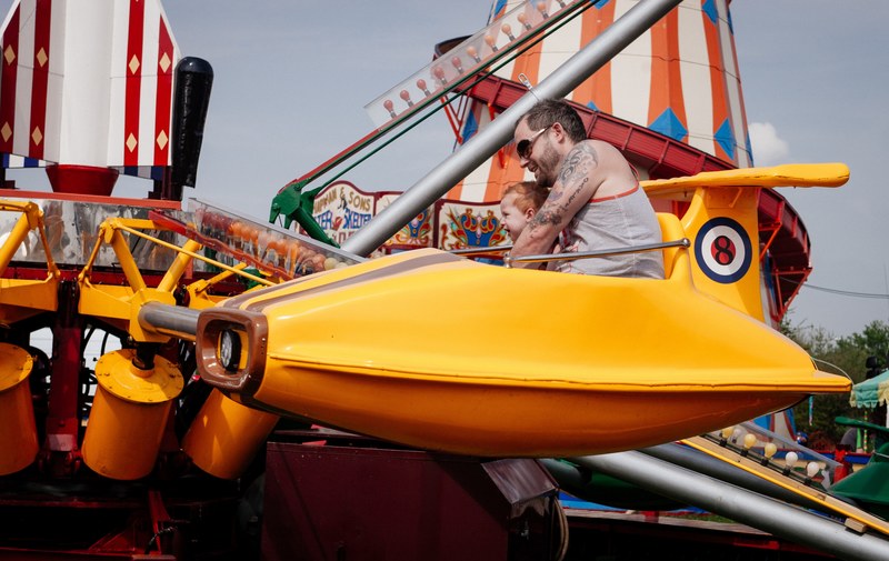 a father and his son ride on a yellow plain at the fair in stotfold, _a father and son on a ride 4k