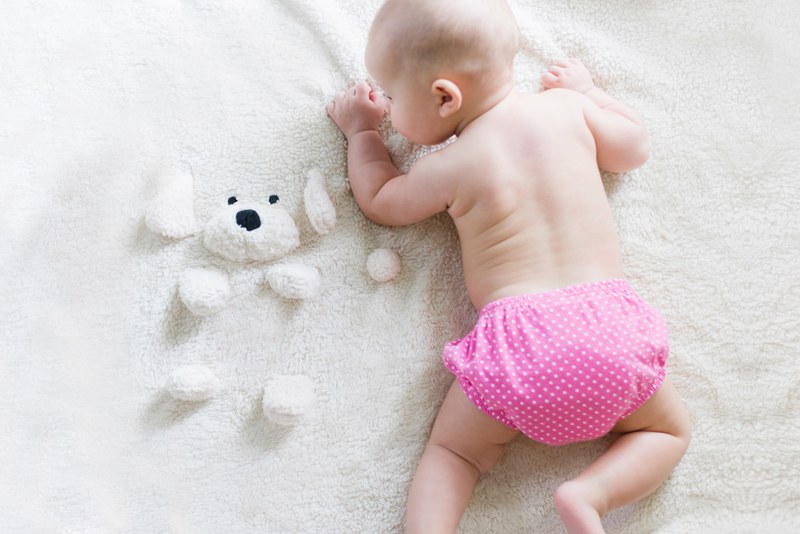 a baby lying on her belly in pink polka dot bottoms, _baby girl 4k