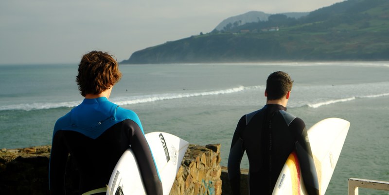 two male surfers walking towards the beach to go surfing, men getting ready to surf 4k