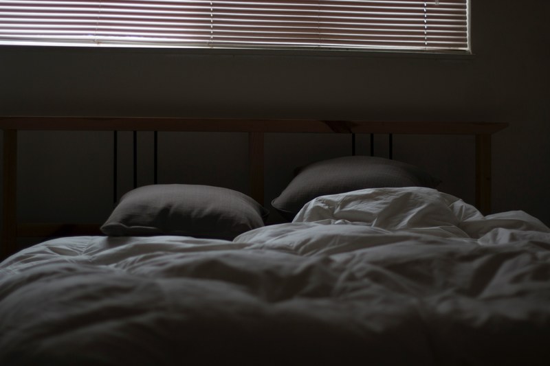 ruffled gray covers and sheets with two pillows and a large window with blinds above it, messy bed and closed blinds 4k