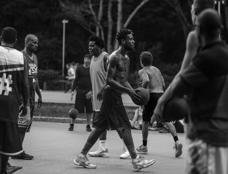 a group of african american men playing basketball together outside, _outdoor basketball game 4k