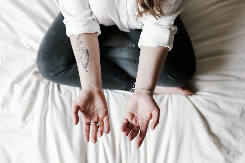 a woman is sitting crossed legged with her arms opened, _tattoo 4k