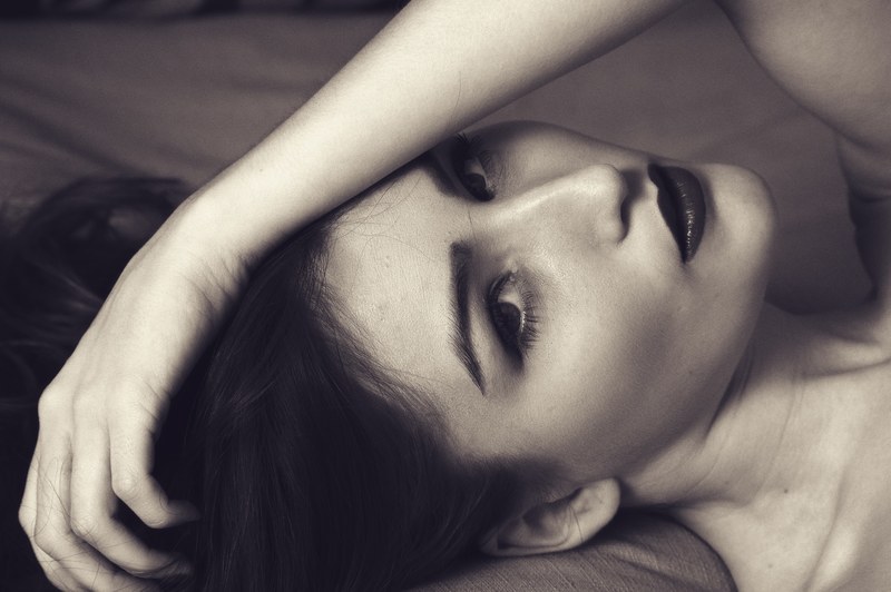 woman laying down sexy portrait hand on face 4k