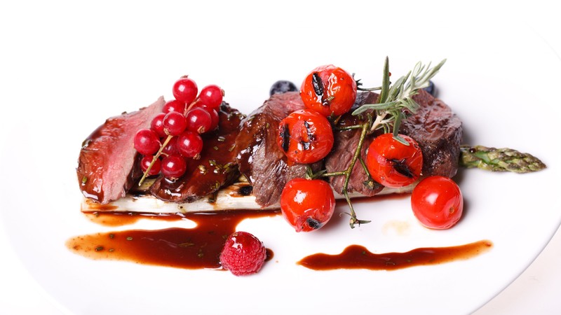 Medallions of pork, meat, asparagus, raspberries, red currant sauce, cherry tomatoes