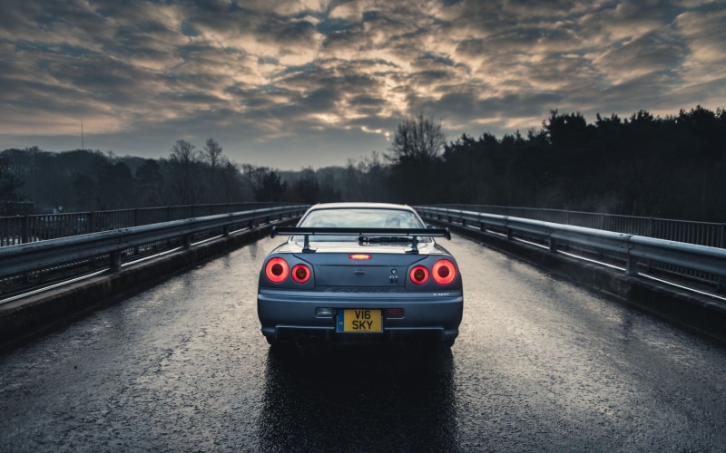 outdoors, sky, car, road, sunset, trees, architecture, land vehicle, on the move, tree, Nissan Skyline GT-R R34, motor vehicle, nature, motion, road trip