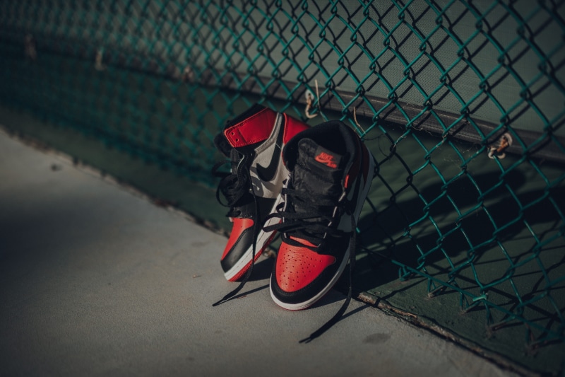 no people, barrier, fence, transportation, footwear, sports, person, nature, jordan, chainlink fence, clothing, team, red, shoe, running shoe, sport, chain