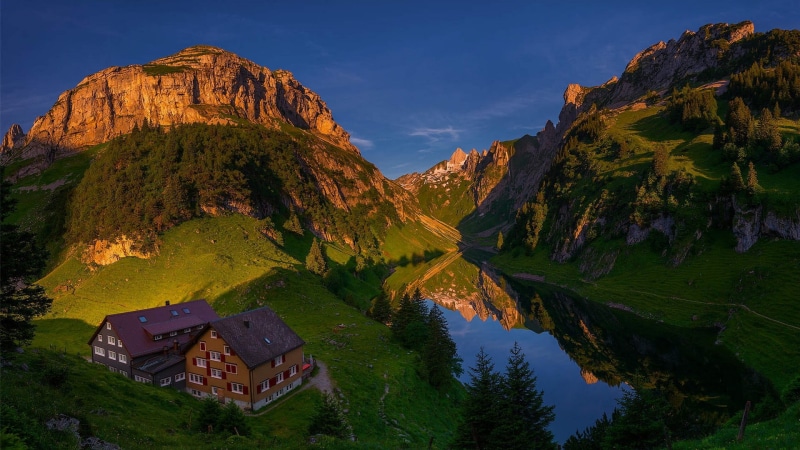 green, landscape, grass, mountain peak, mountain range, beauty in nature, field, mountains, brown, nature, land, outdoors, environment, lake, building exterior