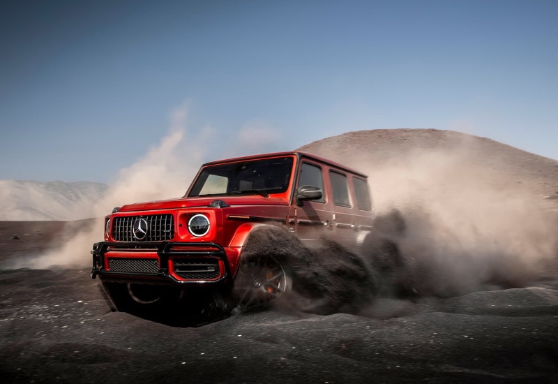 land vehicle, clear sky, motor vehicle, sky, no people, mode of transportation, g63, speed, mercedes-benz, day, dust, nature, red, motion, car, transportation
