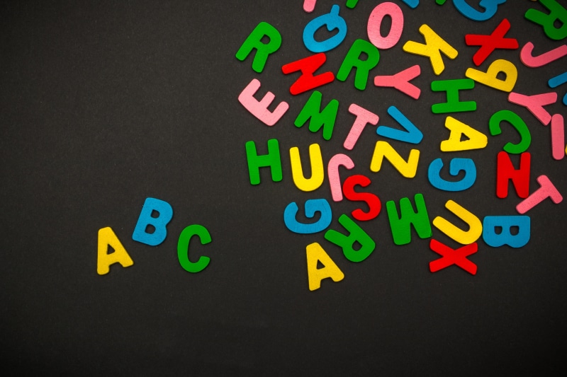 blackboard, capital letter, fonts, multi colored, colorful, paper, blank, large group of objects, number, toy, indoors, yellow, abc, typography, education