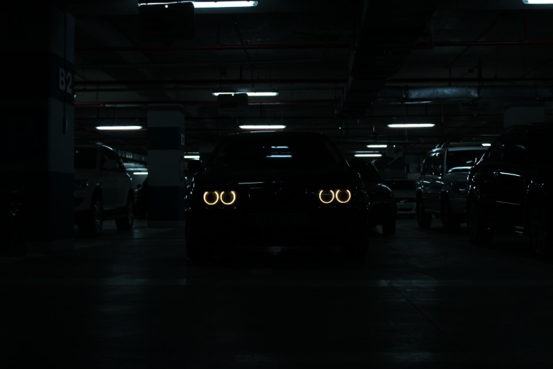motor vehicle, travel, illuminated, incidental people, architecture, dark, public transportation, parking lot, ceiling, transportation, garage, black, architectural column