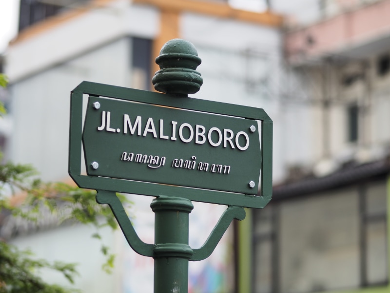 green color, bird, information, no people, banister, message, yogyakarta, street, script, railing, animal, symbol, text, sign, building, information sign