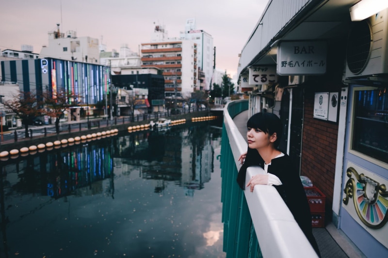 standing, real people, black hair, casual clothing, black clothing, cityscape, women, waist up, young women, young adult, water, built structure, city