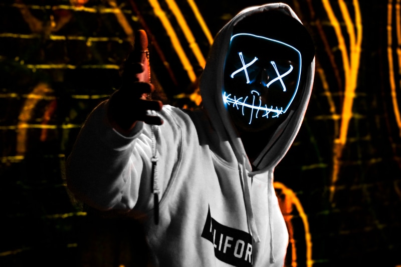 leisure activity, sweater, city, three quarter length, outdoors, reach, western script, one person, led, mask, obscured face, human, california, message