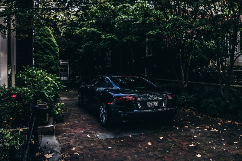 shiny, building exterior, pavement, audi, car, trees, stationary, wheels, transportation system, parked, motor vehicle, landscape, plant, city, mode of transportation