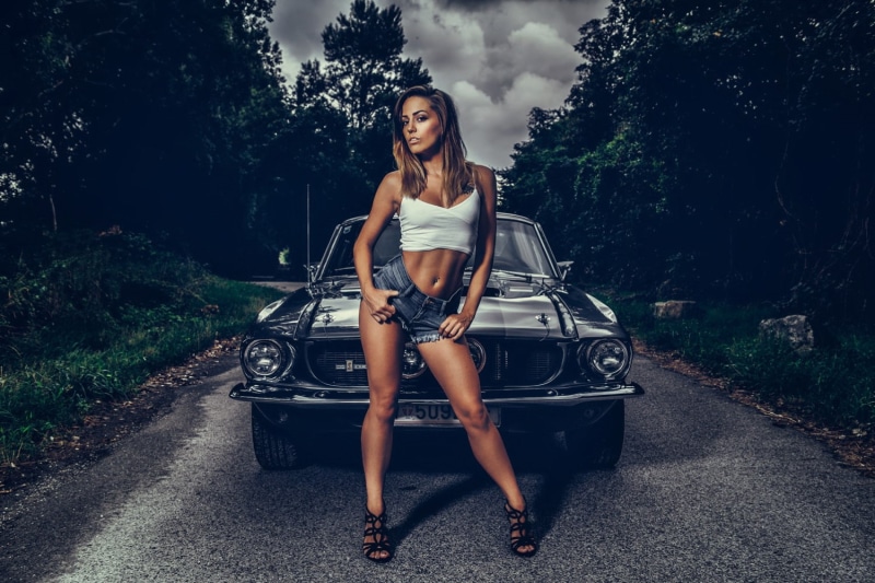 looking at viewer, car, brunette, Shelby, portrait, women with cars, model, trees, women, women outdoors, jean shorts, grass, belly, 720P, heels, pierced navel