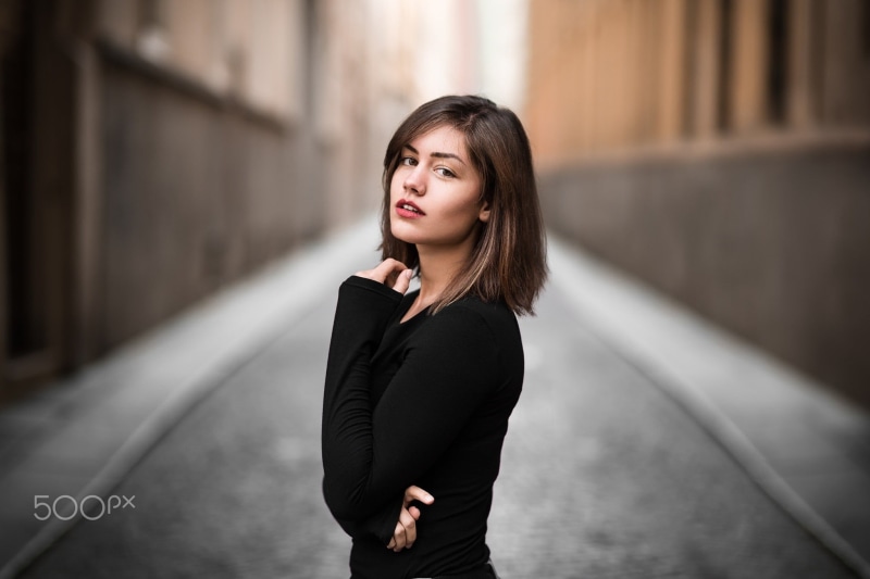 adult, looking at viewer, top, woman, one person, depth of field, street, beauty, sleeved, hairstyle, long hair, real people, straight hair, standing, black