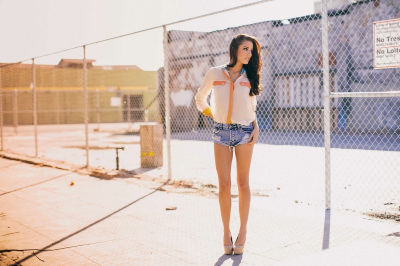 casual clothing, beautiful woman, looking away, building exterior, high heels, young adult, shorts, one person, full length, clothing, lifestyles, jean shorts