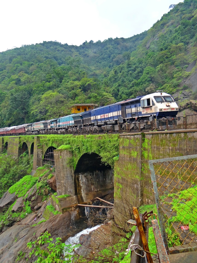 no people, plant, green color, nature, bridge - man made structure, railway bridge, railroad track, track, train - vehicle, trees, mountains, connection