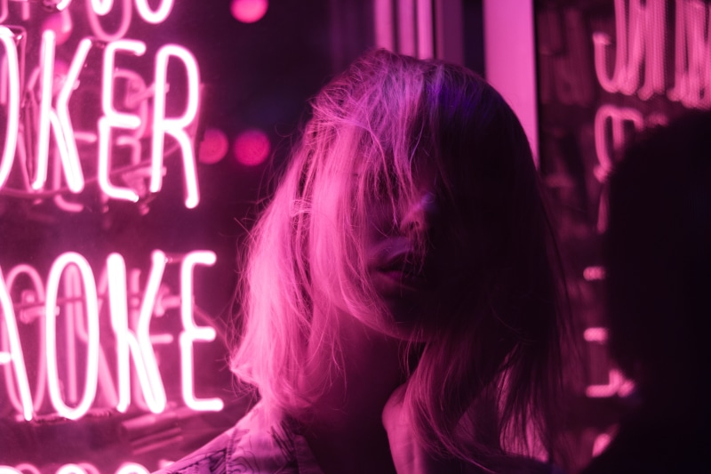 portrait, illuminated, dyed hair, pose, long hair, neon sign, indoors, model, female, focus on foreground, purple, hair, close-up, music, arts culture and entertainment