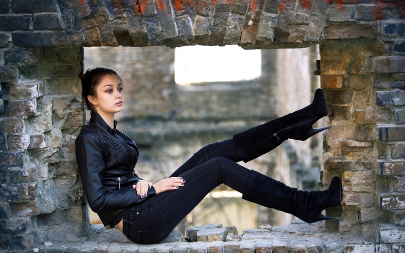 black boots, full length, lifestyles, black jackets, jeans, brick, hairstyle, women outdoors, leather jackets, black nails, wall, sitting, s, black color