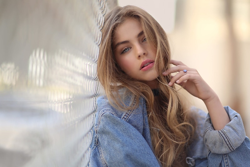 blonde, long hair, face, women, 1080P, portrait, fence, jeans jacket, open mouth, looking at viewer, blue eyes, hair in face, pink lipstick, jade weber