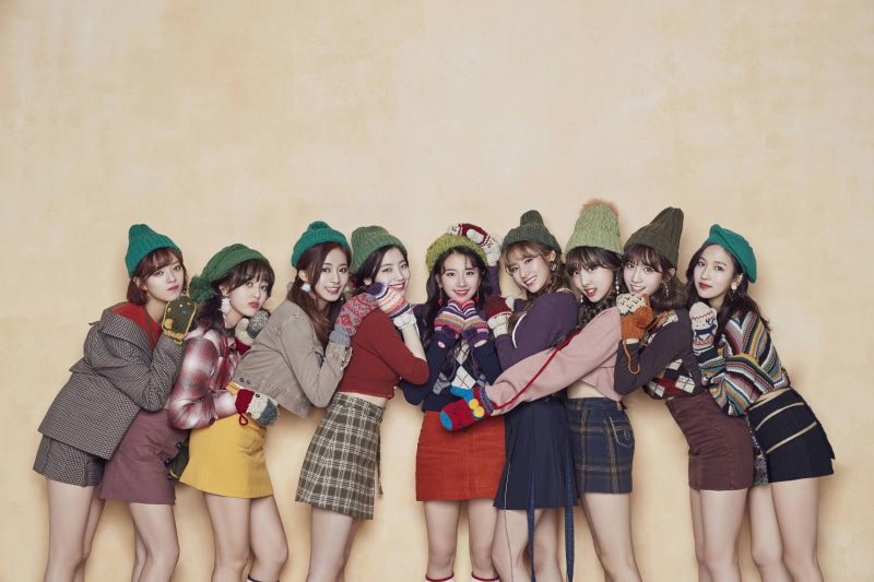 K-pop, singer, front view, smiling, happiness, indoors, warm colors, full length, looking at camera, Christmas, young adult, standing, fun, Twice, holding