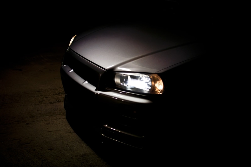 Nissan, silver cars, vehicle front, Japanese cars, closeup, dark background, Nissan Skyline GT-R R34 V-Spec II, Headlights, grey cars, Nissan Skyline R34