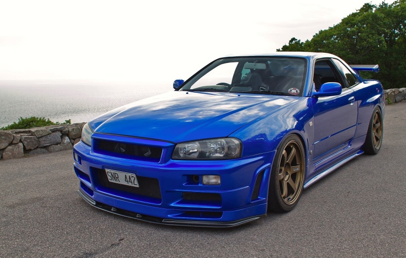 blue, Fail Crew, motor vehicle, sea, JDM, Japan, parking, outdoors, Nissan Skyline GT-R R34 V-Spec II, no people, stationary, Nissan, Skyline R34, city