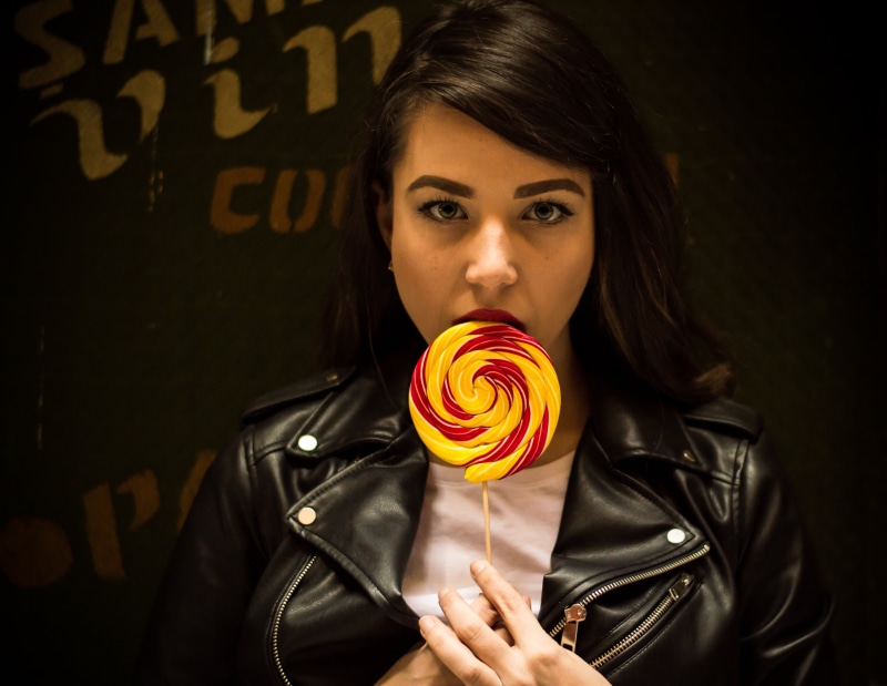 seductive, dog, lollipop, girl, lifestyles, jacket, street, front view, eye, candy bar, yellow, beauty, women, indoors, innocence, fashion, lip, sweet food
