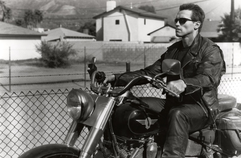 people, young adult, riding, arnold, schwarzenegger, fence, fashion, three quarter length, transportation, motorcycle, adult, sunglasses, mode of transportation