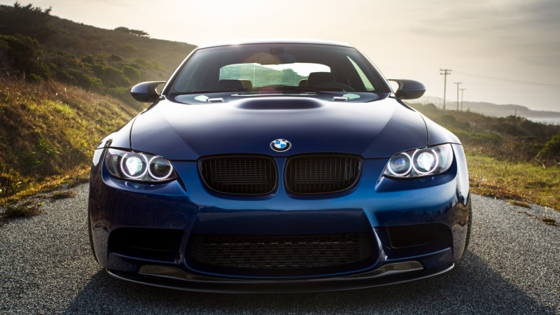front view, close-up, retro styled, mode of transportation, BMW E92 M3, blue cars, plant, no people, security, headlight, blue, focus on foreground, motor vehicle