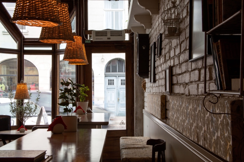 no people, table, door, nature, built structure, shop, chair, indoors, entrance, sunlight, building, interior, electric lamp, architecture, coffee shop