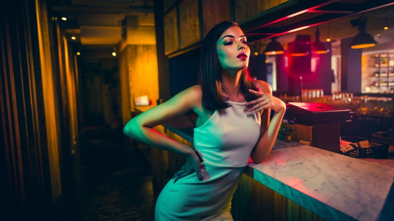 brunette, one person, three quarter length, white, table, 1080P, real people, dress, hands on hips, model, spaghetti, fashion, nightlife, adult, illuminated