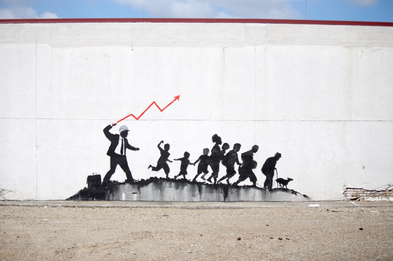 Banksy, group, group of people, urban, arms raised, adult, sitting, concrete, men, wall - building feature, people, built structure, women, graffiti, wall