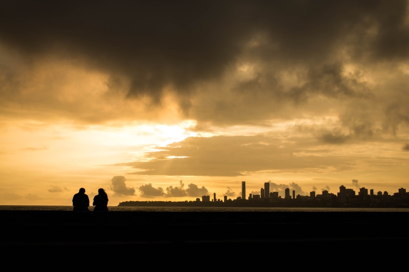 man, real people, marine drive, landscape, men, togetherness, cloud - sky, architecture, scenics - nature, bombay, city, outdoors, sun, sitting, cloudscape