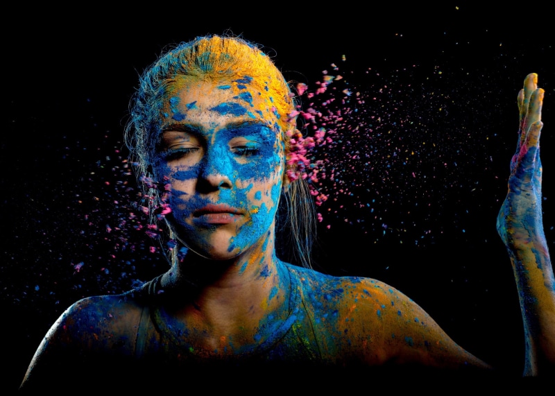 body paint, celebration, young adult, powder paint, paint, black background, multi colored, headshot, one person, face paint, adult, portrait, holi, dark