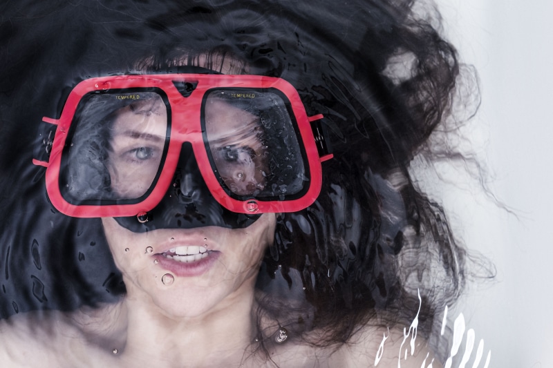 eyeglasses, child, close-up, women, one woman only, whimsical, teeth, lazy, headshot, lying, innocence, looking at camera, body part, one Person, pretty