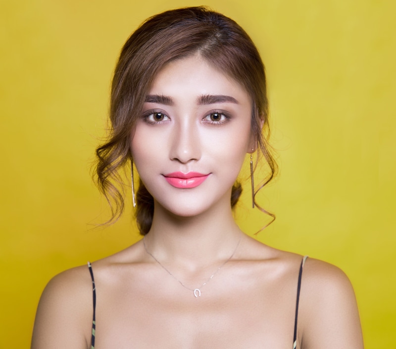 front view, strap, wearing, one person, brown hair, face, style, studio shot, beautiful, glamour, fashion, adult, lipstick, women, jewelry, posing, colored background