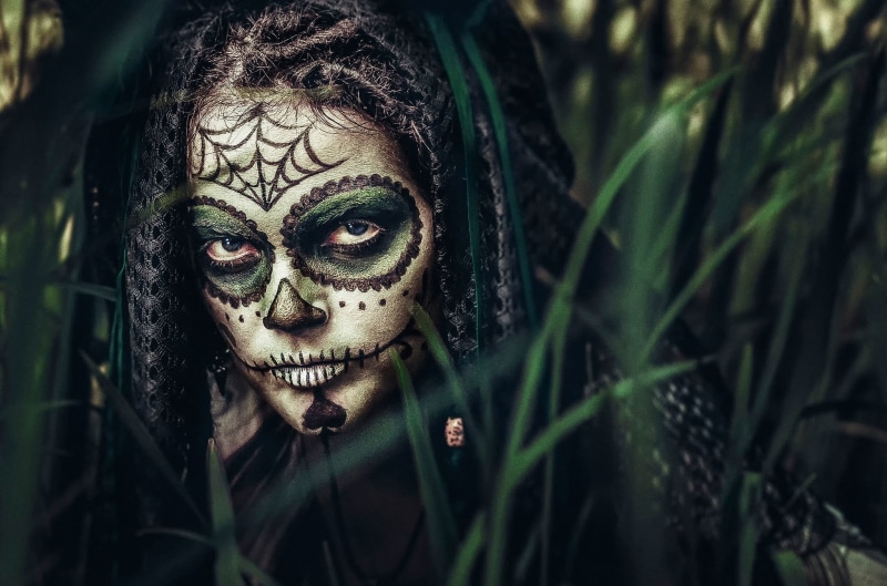 plant, adult, human face, real people, close-up, Dia de los Muertos, looking at camera, outdoors, front view, fantasy girl, face paint, paint, jungle, evil
