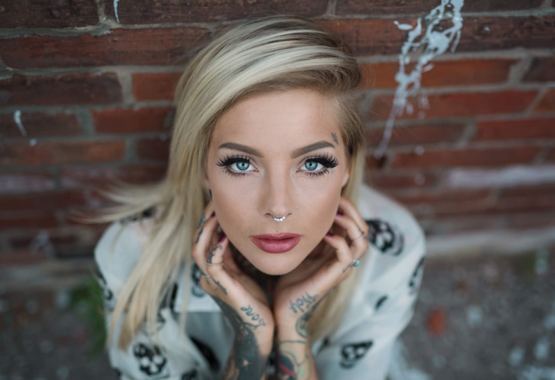 brick, young adult, young women, tattoo, brick wall, blond hair, front view, hair, face, hairstyle, nose rings, portrait, blonde, one person, adult, looking at camera